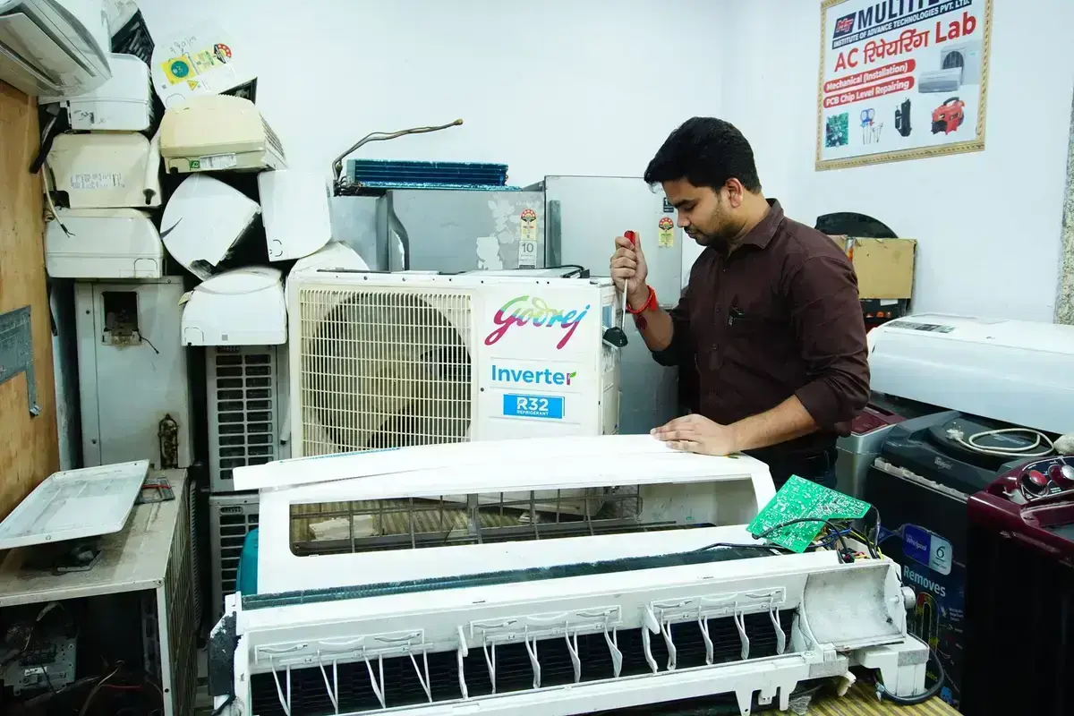 Technician repairing an air-conditioning unit on the bench