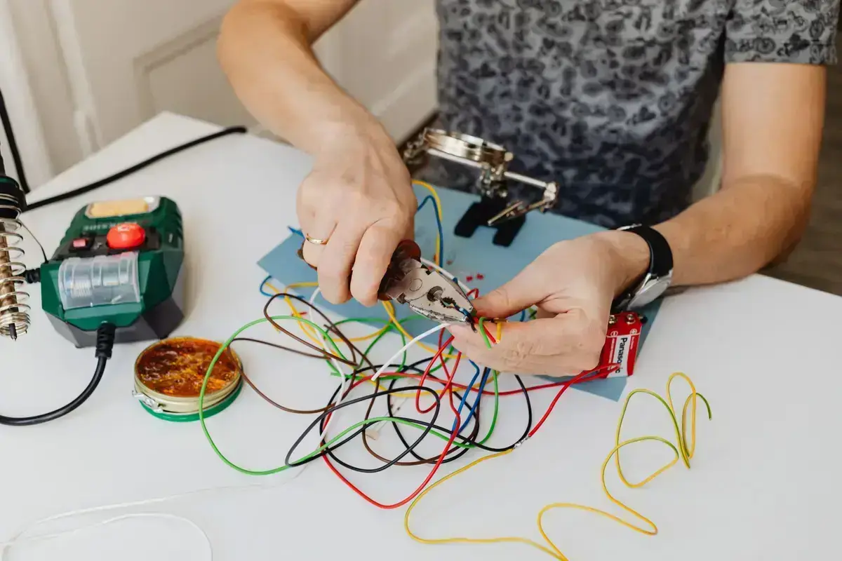 Electrician cutting and dressing circuit cables at a residential board