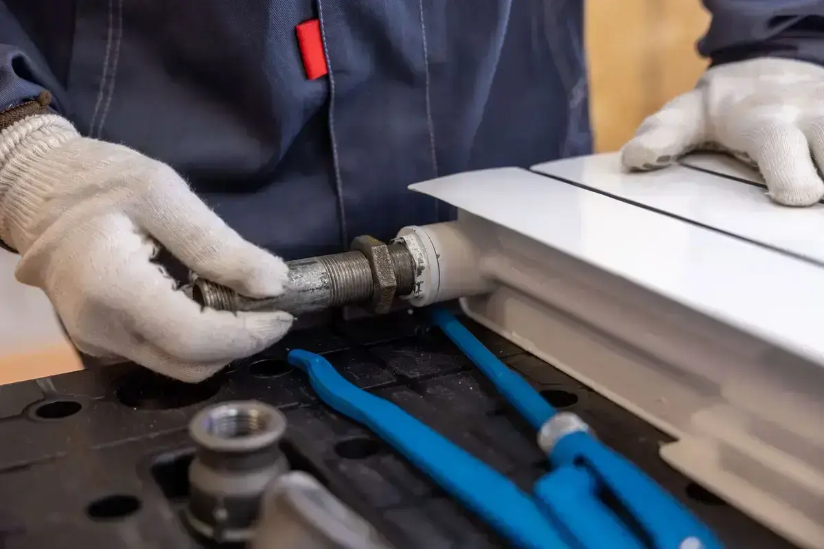 Plumber fitting a pipe joint with a specialist wrench